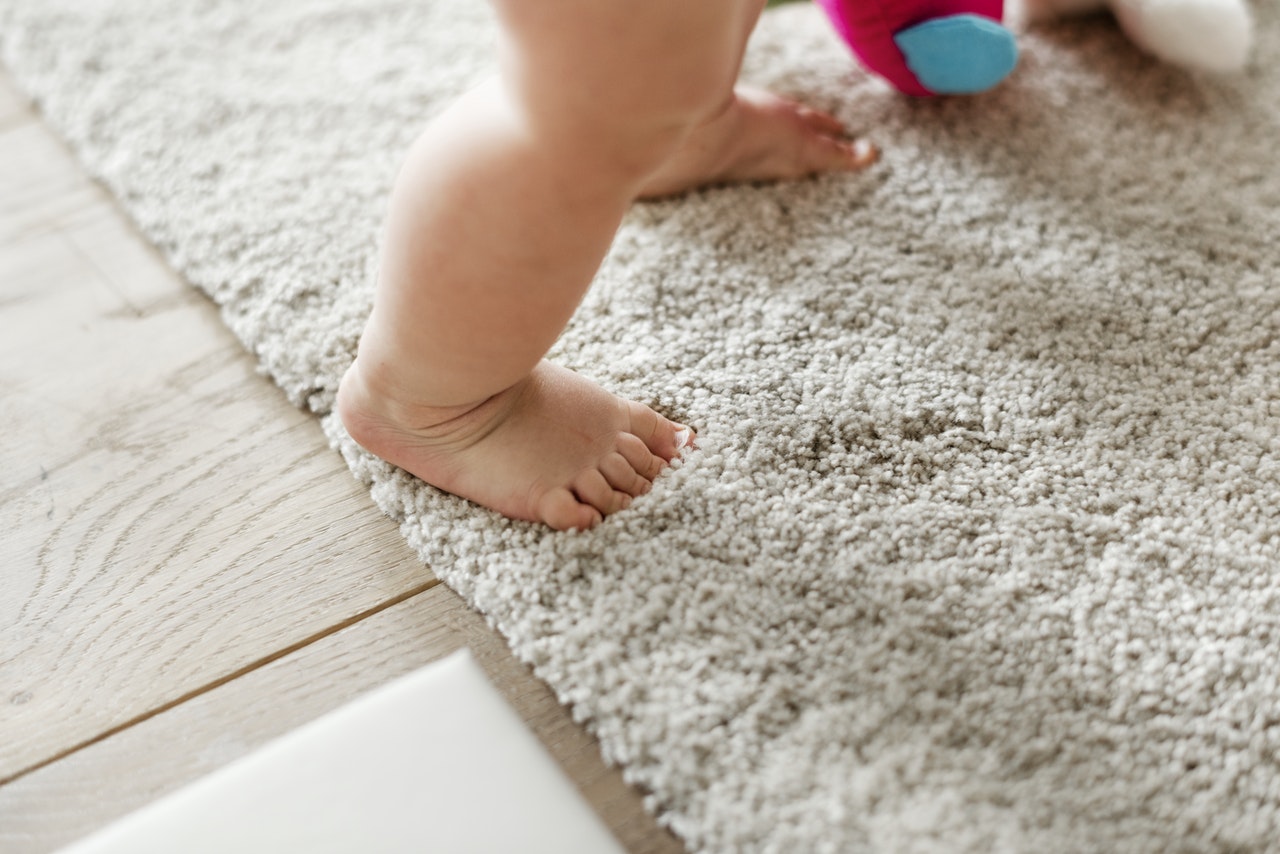 a baby standing on a carpet